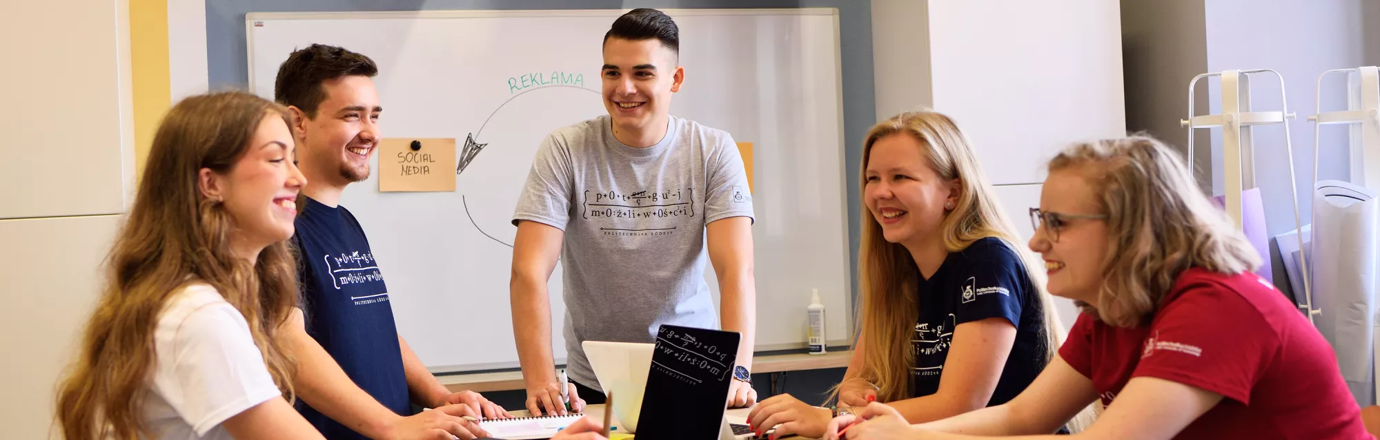 A group of students talking in a classroom. 