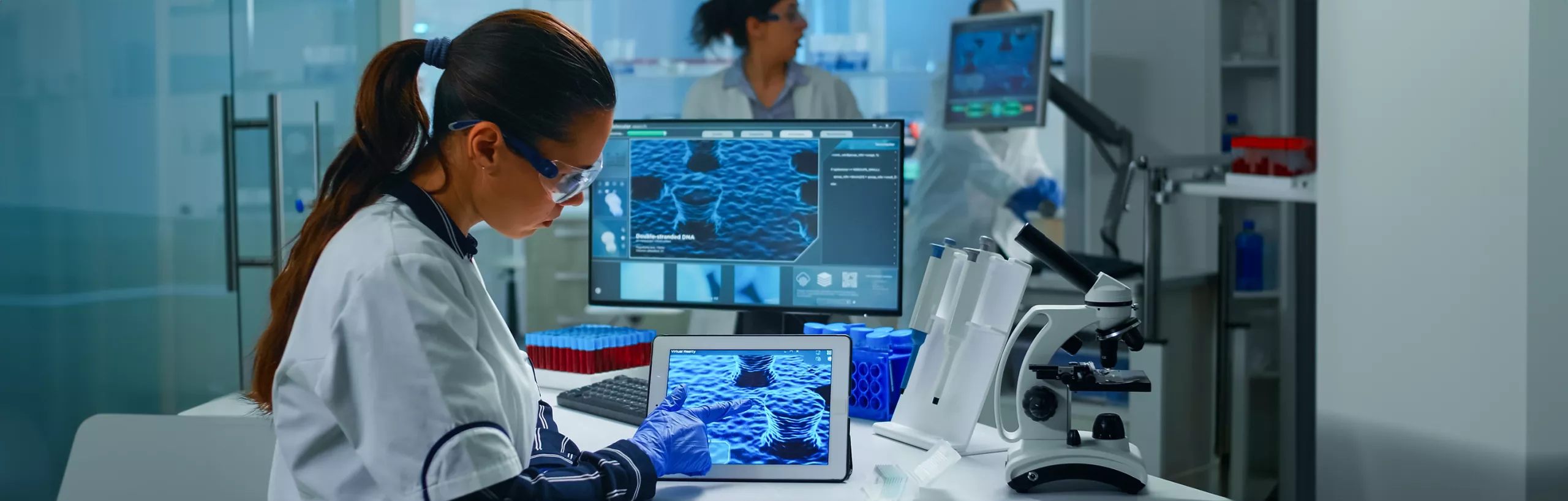 Kobieta pracuje przy urządzeniu w laboratorium medycznym. 